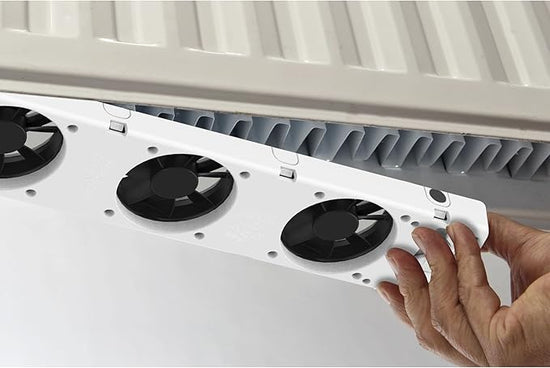 Close-up of a person installing a white Heizkörperventilator on a white Heizkörperventilator